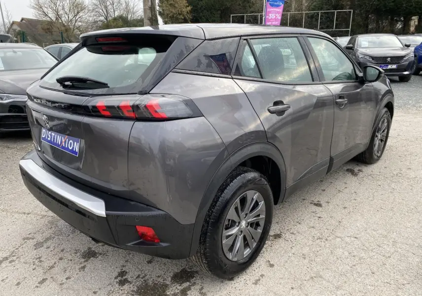 Peugeot 2008 gris foncé vue 3/4 arrière droit, feux arrière LED 3 griffes et jantes alliage visibles.