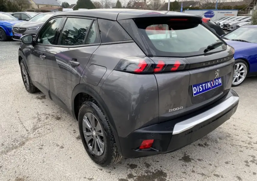 Peugeot 2008 gris foncé vue 3/4 arrière droit, feux arrière LED à trois griffes et toit noir contrasté.