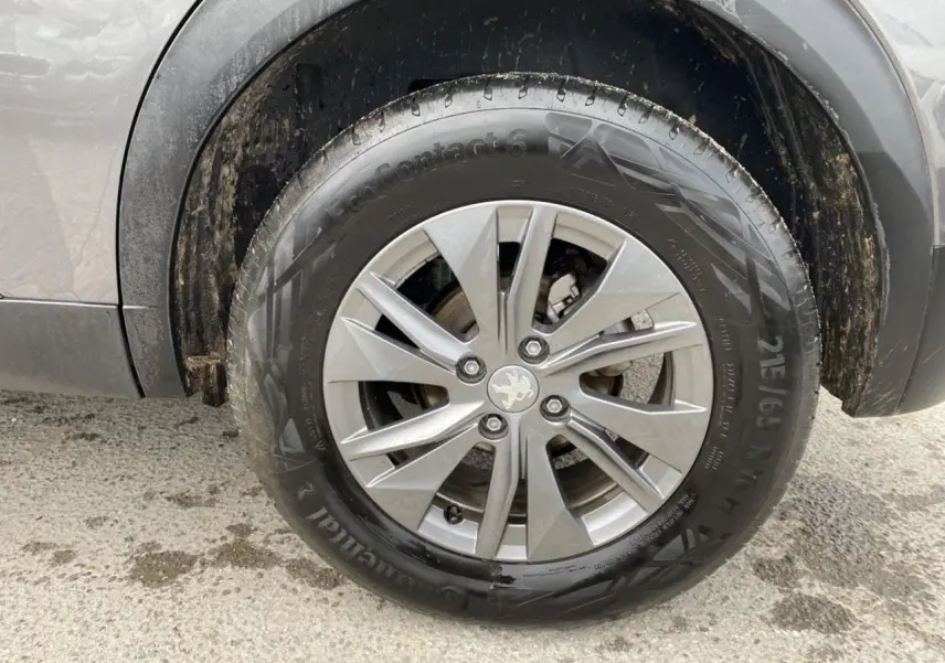 Gros plan sur la roue avant droite gris foncé d'un Peugeot 2008 2021 avec jante alliage et logo lion au centre.