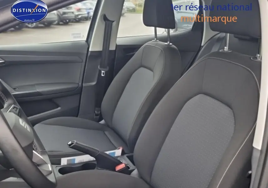 Vue intérieure côté gauche montrant les sièges avant gris tissu de la SEAT Ibiza 2025 avec volant multifonction cuir.