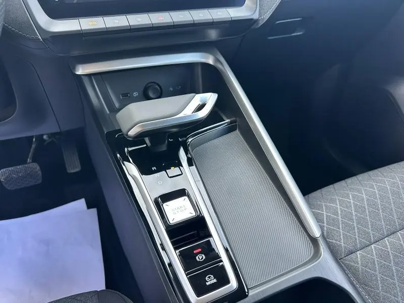 Vue rapprochée de la console centrale noire du MG ZS Hybrid+ 2025 avec levier de vitesse automatique et bouton start/stop.