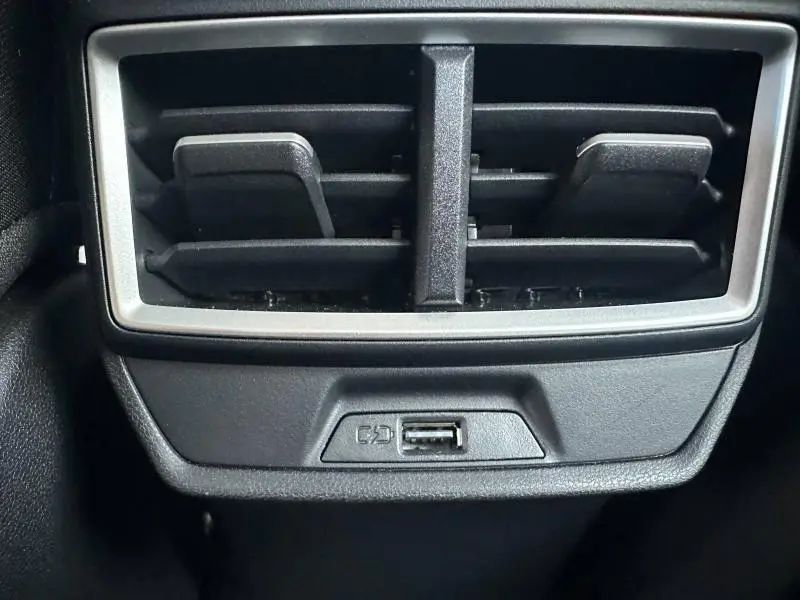 Gros plan sur la sortie d'air arrière noire avec prise USB intégrée dans l'habitacle du MG ZS blanc.