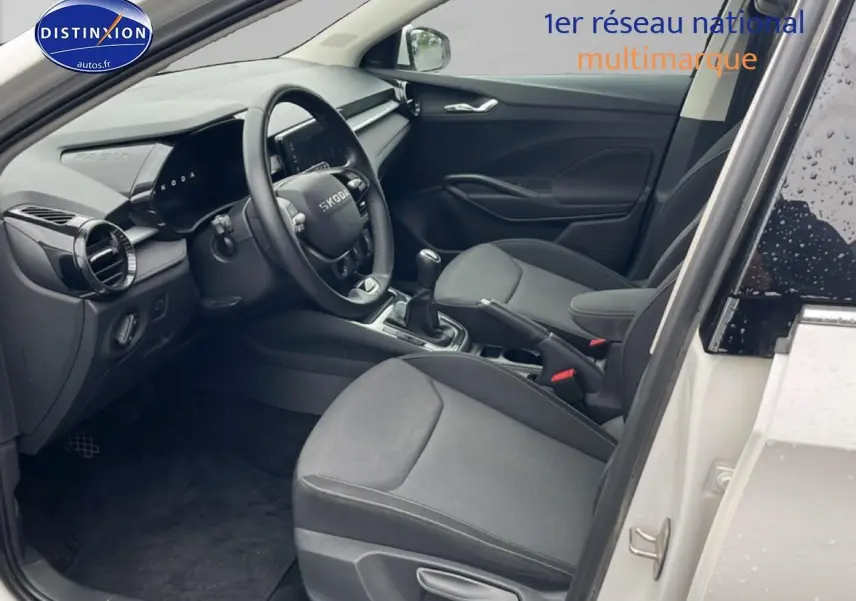 Intérieur de la Skoda Fabia blanc, vue côté conducteur avec volant cuir et boîte manuelle visible.