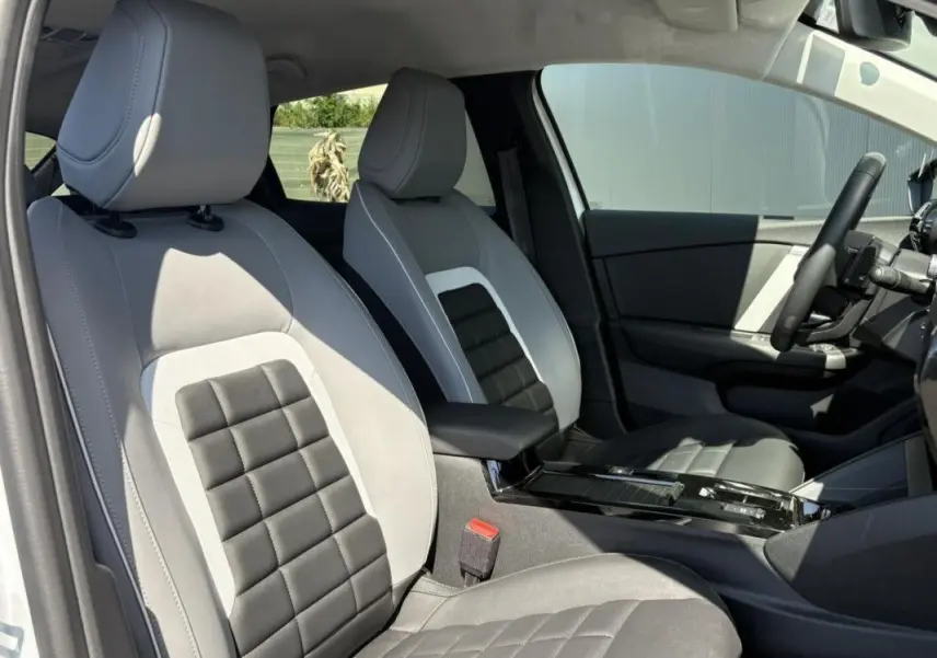 Vue intérieure côté conducteur de la Citroën C4 Hybrid 145 ch 2025 avec sièges bi-ton gris clair et foncé.