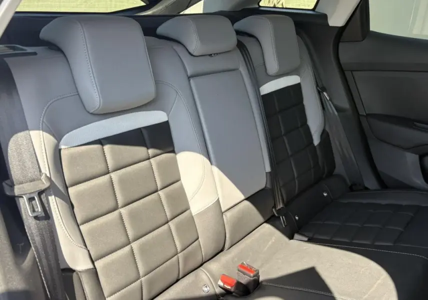 Vue intérieure des sièges arrière en cuir noir et gris de la Citroën C4 Hybrid 2025, avec appuie-têtes et ceintures visibles.