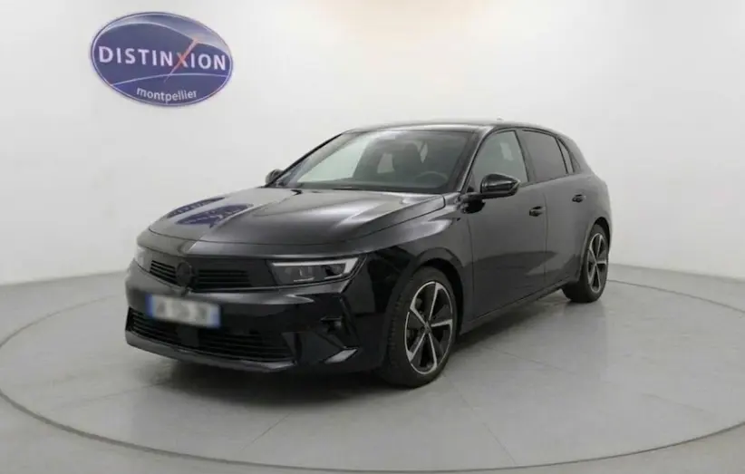 Opel Astra 2025 noire vue 3/4 avant droit dans un studio avec jantes alliage 17 pouces et vitres surteintées.