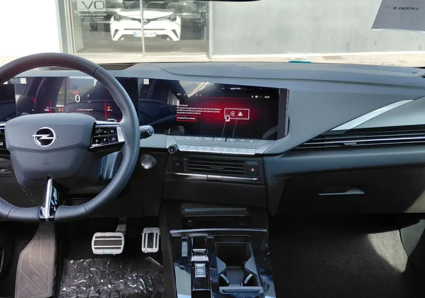 Vue intérieure frontale de l’Opel Astra 2025 noire, avec tableau de bord numérique et volant cuir multifonction.