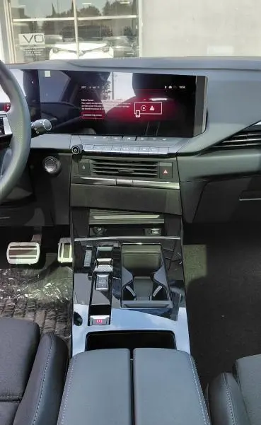 Intérieur avant de l’Opel Astra 2025 noir, vue centrée sur la console avec écran tactile et volant cuir.