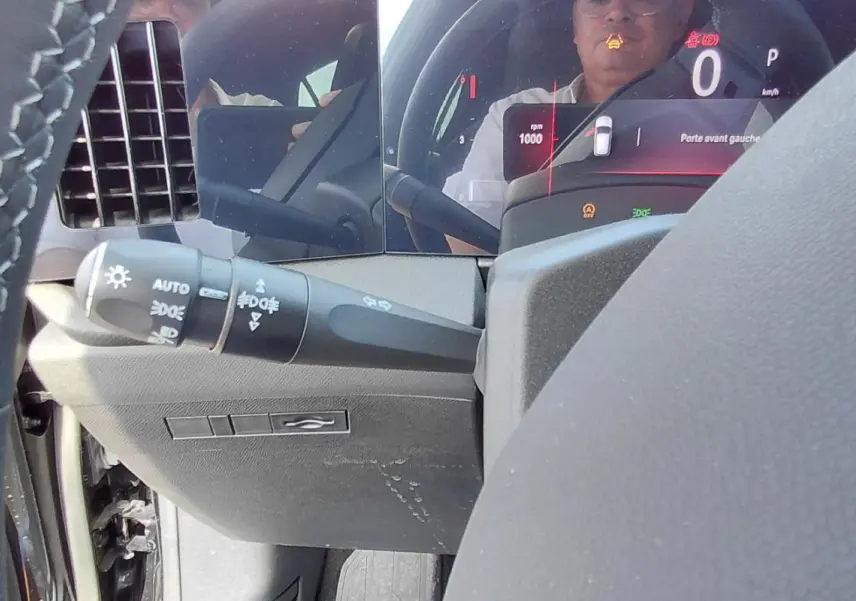 Gros plan sur le volant cuir et le combiné numérique de l’Opel Astra noire, affichant le tableau de bord digital.