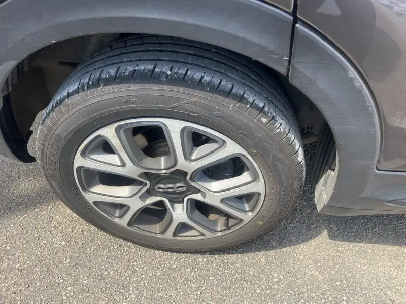 Gros plan sur la roue avant droite d'une FIAT 500X bronze métallisé avec jante alliage distinctive.