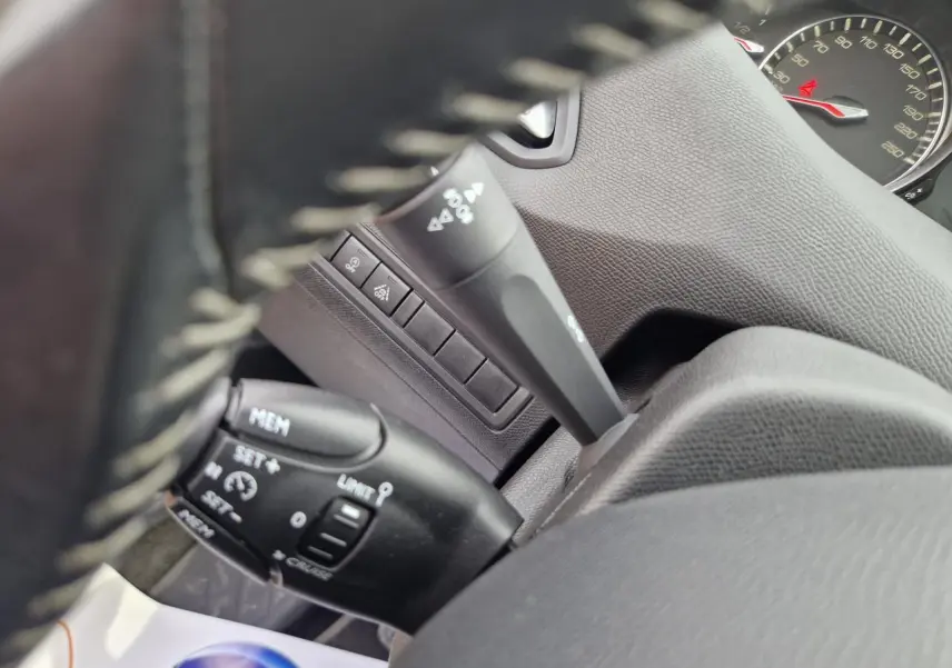 Gros plan sur les commandes de régulateur de vitesse et limiteur, tableau de bord gris intérieur Peugeot 308 2018.