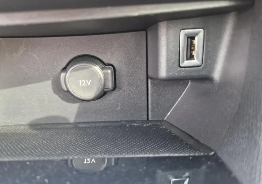 Prise 12V et port USB en gros plan sur la console centrale intérieure d'une Peugeot 308 gris artense de 2018