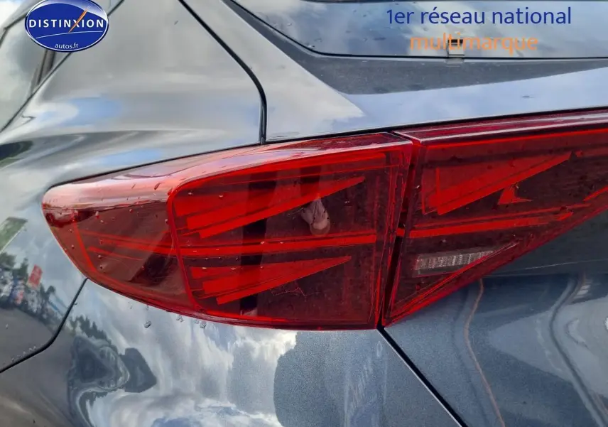 Gros plan sur le feu arrière droit du CUPRA Formentor gris magnétique 2025 avec reflets du ciel sur la carrosserie.