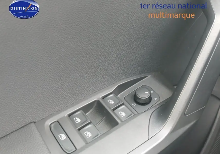 Gros plan sur les commandes de vitres électriques et rétroviseurs côté conducteur d'une SEAT Ibiza blanc Nevada.