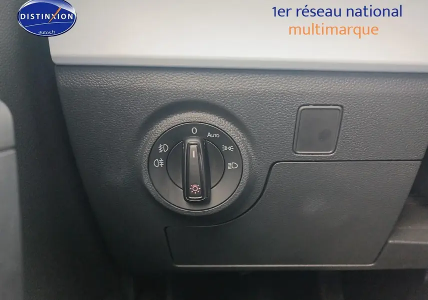 Gros plan sur le bouton de commande des phares dans l'habitacle de la SEAT Ibiza blanc Nevada 2025.