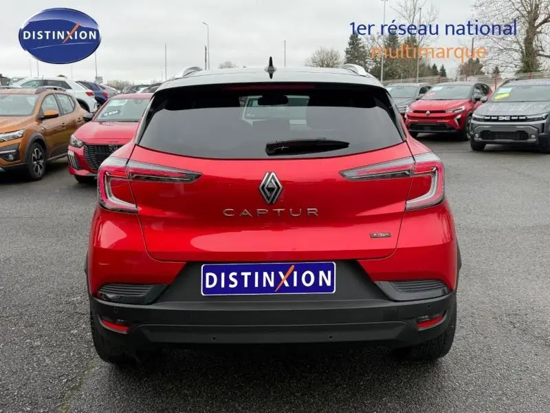 Vue arrière d'un Renault Captur 2025 rouge flamme, version hybride full hybrid 1.6 E-Tech avec logo et feux LED distinctifs.