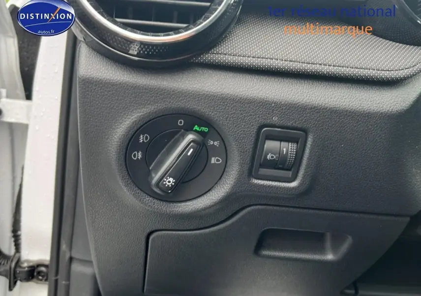 Détail du tableau de bord côté gauche d'une Skoda Fabia blanche 2025, avec commande des phares et réglage d'intensité.