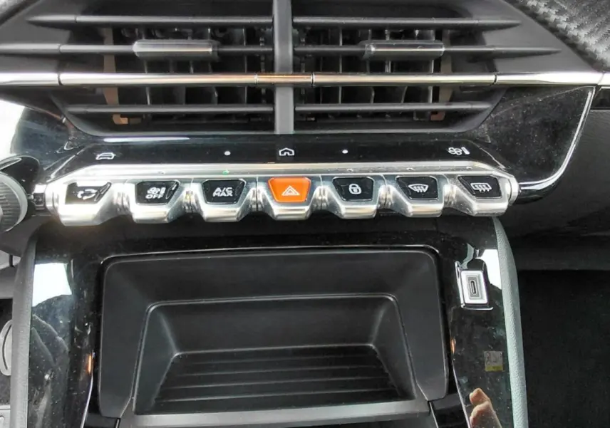 Vue rapprochée de la console centrale du Peugeot 2008 Hybrid 145 e-DCS6 Style 2025, boutons piano noirs et chrome.