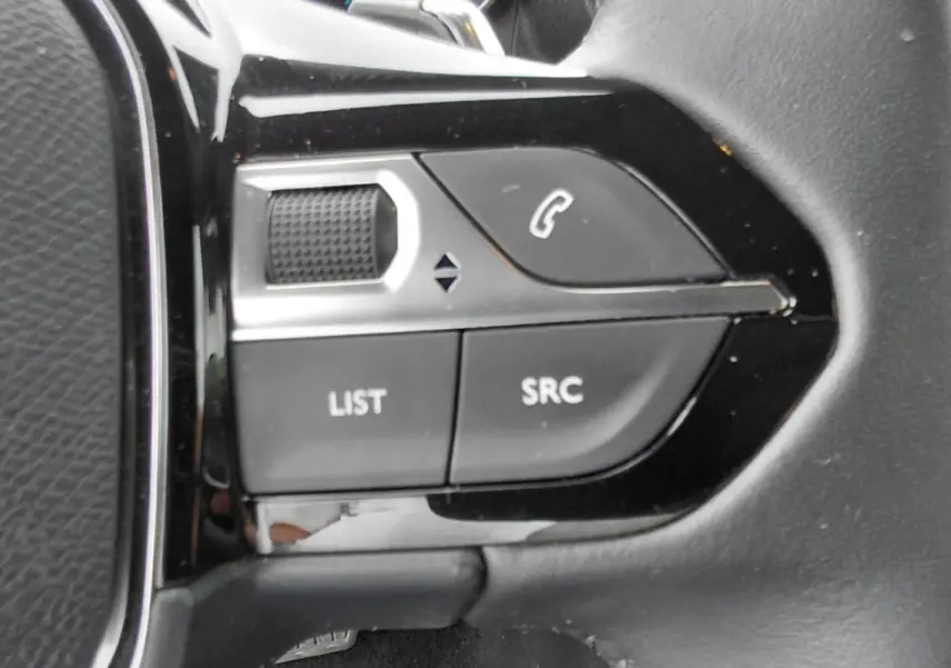 Gros plan sur les commandes gauche du volant noir du Peugeot 2008 Hybrid 145 e-DCS6 Style 2025.
