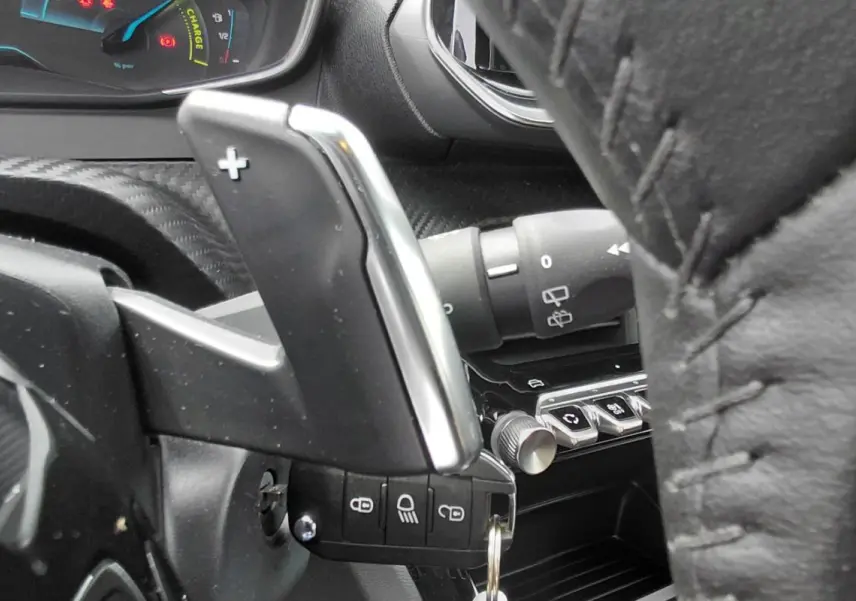 Détail de la palette de changement de vitesse au volant dans l’habitacle noir du Peugeot 2008 Hybrid 145 e-DCS6 Style 2025.