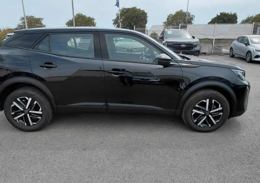 Peugeot 2008 Hybrid 145 e-DCS6 Style noir vu de profil côté gauche sur un parking extérieur.