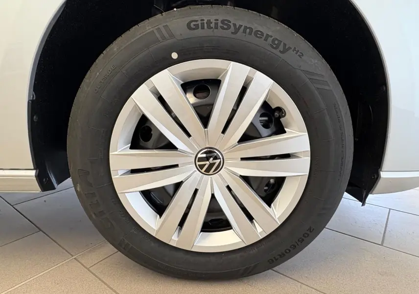 Gros plan sur la roue avant droite du Volkswagen Caddy gris argent 2025, avec jante à enjoliveur moderne.