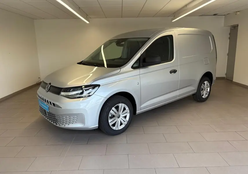 Vue 3/4 avant droit d'un Volkswagen Caddy 2025 gris argent, utilitaire compact avec calandre moderne et jantes simples.