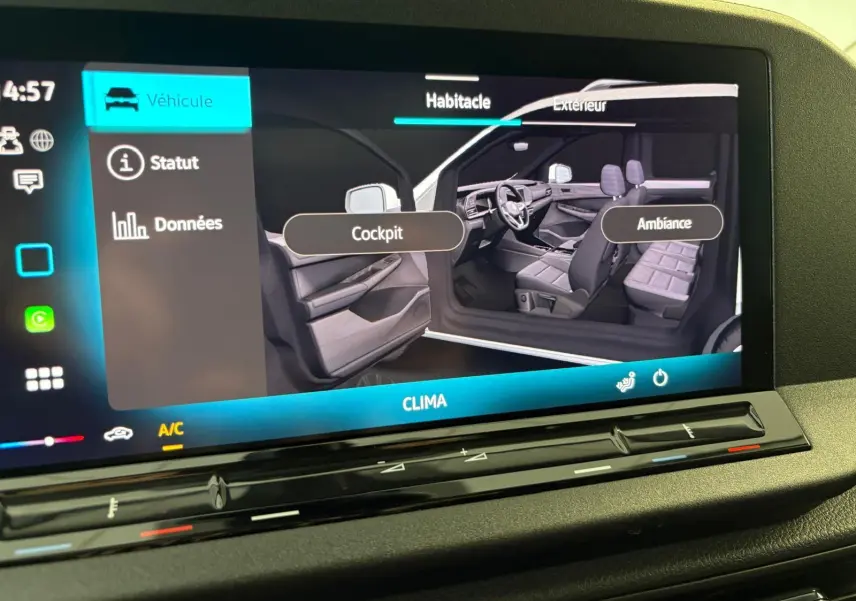Écran tactile montrant l'intérieur du Volkswagen Caddy 2025, vue côté gauche avec sièges et tableau de bord gris.