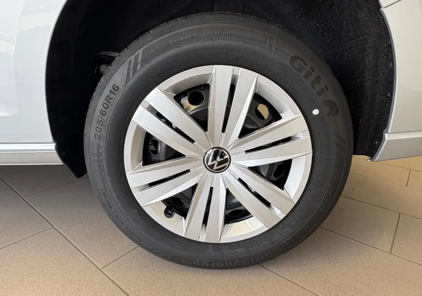 Gros plan sur la roue avant droite d'un Volkswagen Caddy gris argent 2025 avec jante en alliage et pneu Giti.