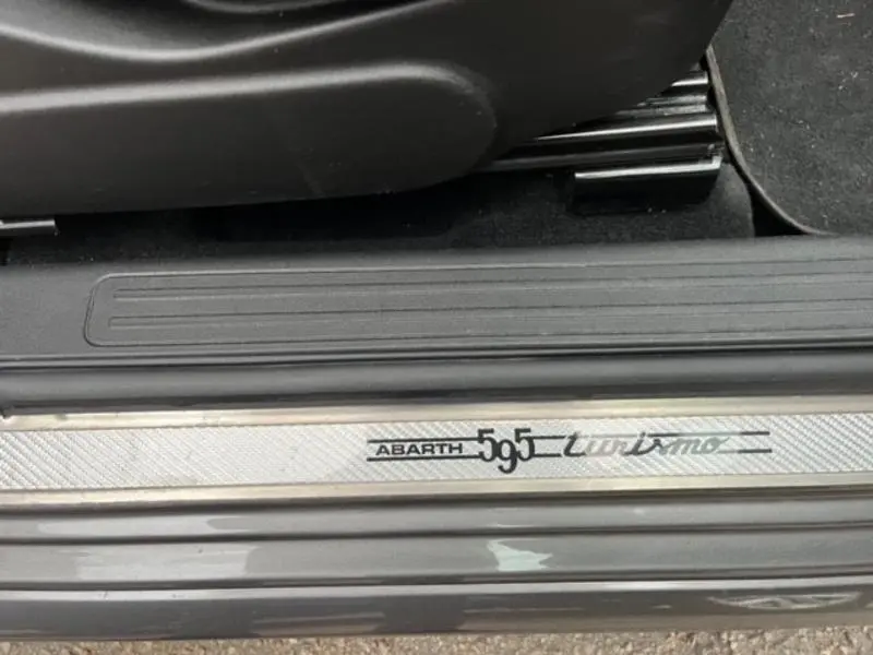 Gros plan sur la plaque de seuil de porte "Abarth 595 Turismo" d'une ABARTH 500 gris foncé métal.