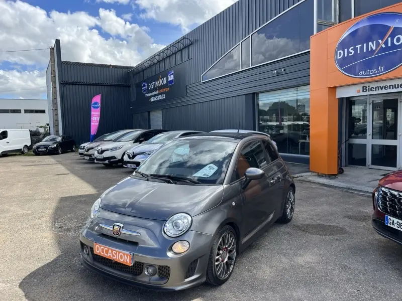 ABARTH 500 gris foncé métal en 3/4 avant droit avec jantes alliage et becquet arrière visible devant un garage.