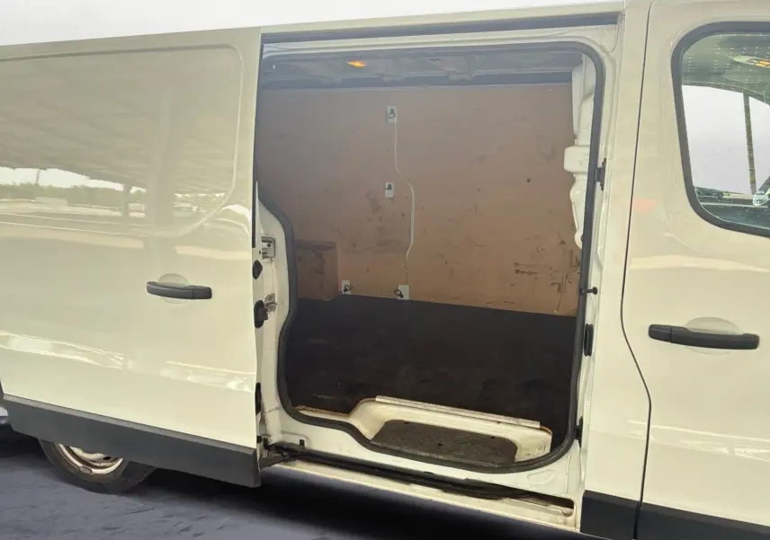 Vue latérale droite d'un Renault Trafic Fourgon blanc 2022 avec porte coulissante ouverte montrant l'espace de chargement vide.