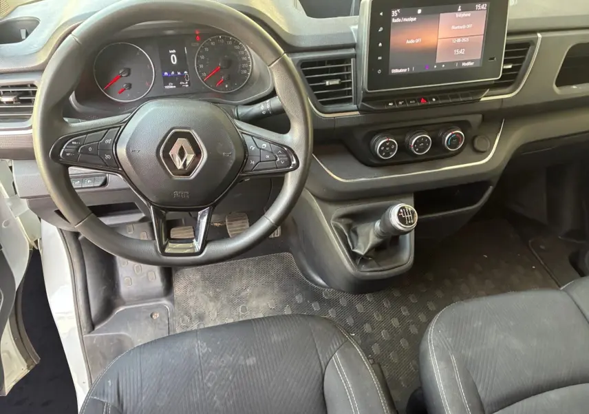 Vue intérieure du tableau de bord du Renault Trafic Fourgon blanc 2022, volant multifonctions et écran tactile 8 pouces.