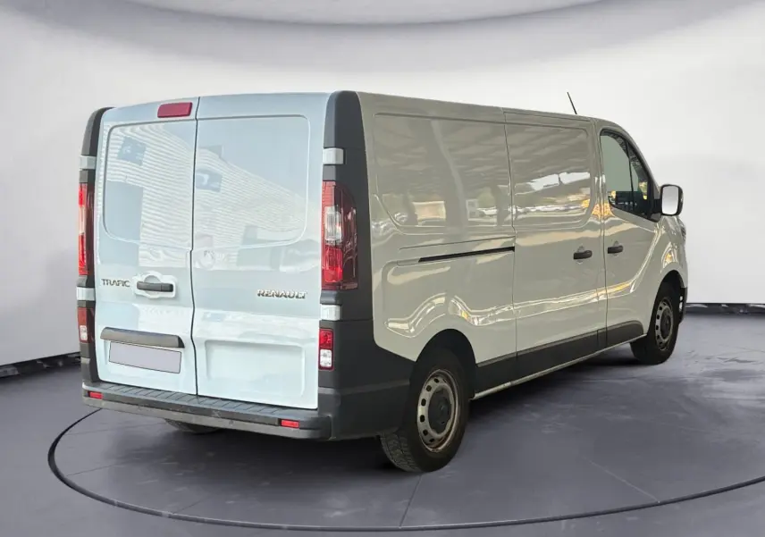 Renault Trafic Fourgon blanc vu en 3/4 arrière droit, avec portes arrière fermées et jantes acier noires.