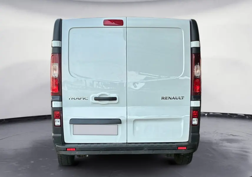 Vue arrière d'un fourgon blanc Renault Trafic L2H1 3T avec portes battantes et feux verticaux rouges.