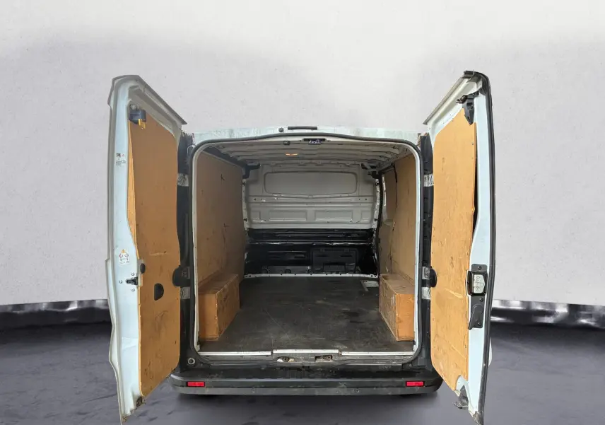 Vue arrière du Renault Trafic Fourgon blanc 2022 avec portes ouvertes montrant l'intérieur vide et panneaux en bois.