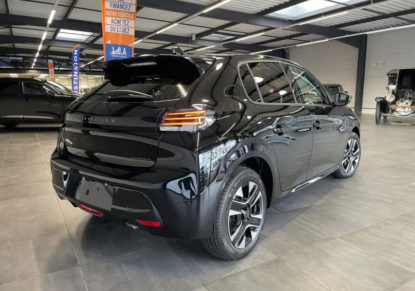 Vue 3/4 arrière droite d'une Peugeot 208 noire hybride 2025 avec jantes alliage 16 pouces et feux LED distinctifs.