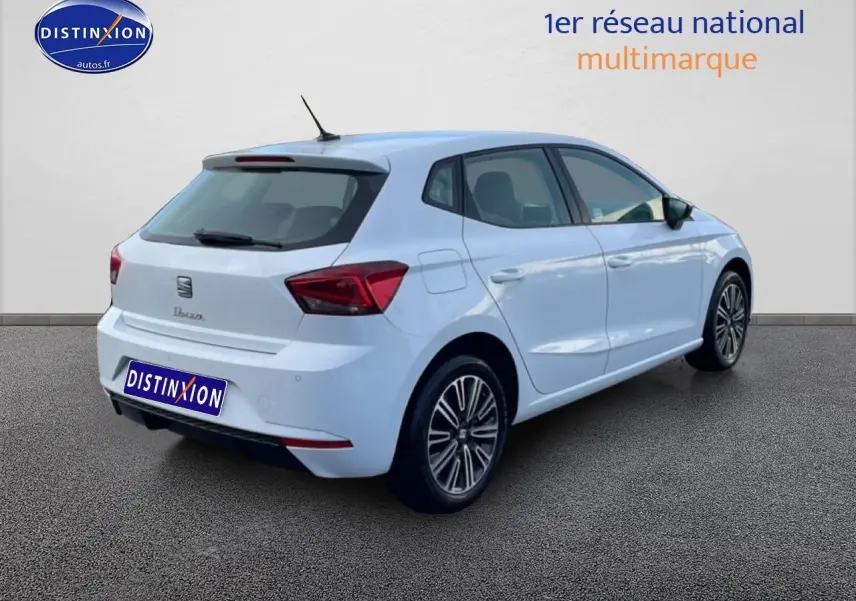 Vue 3/4 arrière droite d'une SEAT Ibiza blanche Nevada avec jantes alliage et feux arrière LED triangulaires.