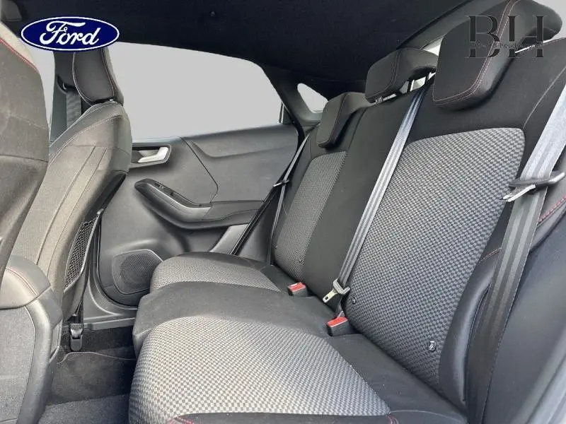 Vue intérieure côté droit sur la banquette arrière noire avec tissu à motifs et surpiqûres rouges du Ford Puma 2020.
