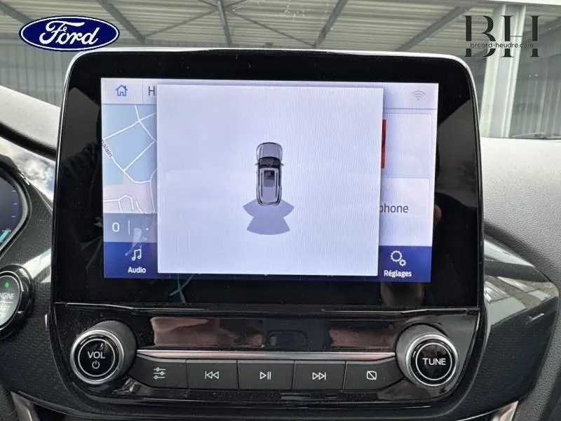 Écran tactile central de la Ford Puma 2020 montrant l'assistance au stationnement, intérieur noir brillant.