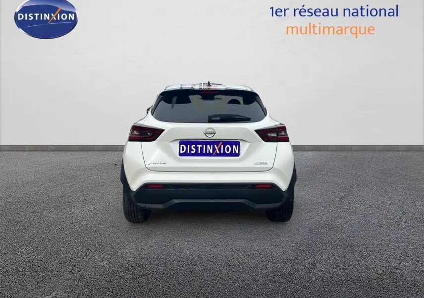 Vue arrière d'un Nissan Juke blanc nacré 2024 avec feux LED et logo Nissan bien visibles.
