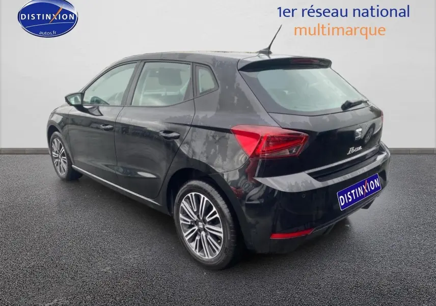 Vue 3/4 arrière droite d'une SEAT Ibiza noir minuit avec jantes alliage et signature Ibiza manuscrite sur le hayon.
