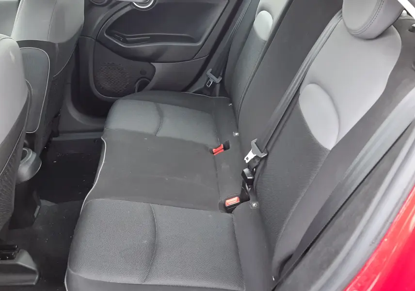 Vue intérieure côté droit des sièges arrière en tissu gris foncé d'une FIAT 500X rouge de 2016, version Lounge.