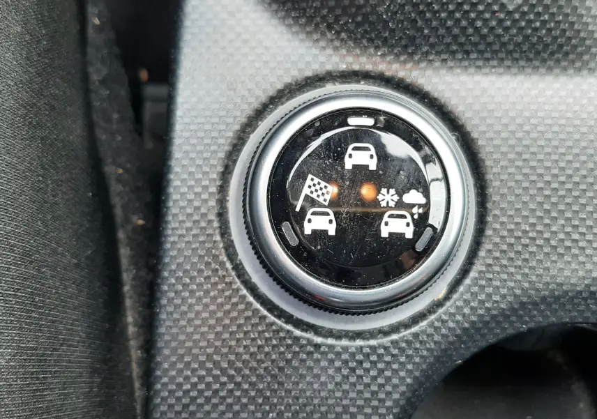 Gros plan sur le sélecteur de mode de conduite du Fiat 500X rouge, montrant les icônes de terrain et météo.