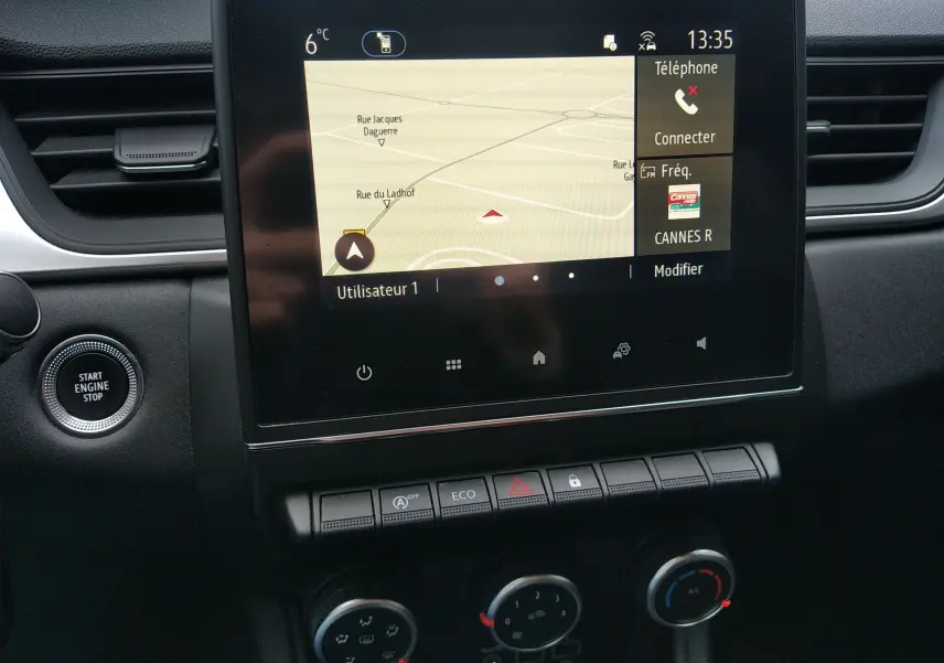 Vue rapprochée de l’écran tactile central du Renault Captur noir 2021 avec navigation et commandes climatisation visibles.
