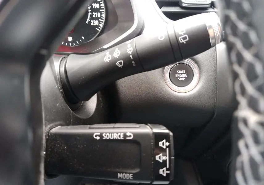 Détail de l’intérieur du Renault Captur 2021 noir, bouton start engine stop et commandes au volant visibles côté gauche.