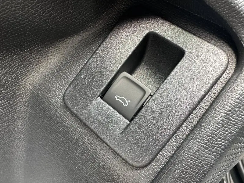 Gros plan sur le bouton d'ouverture électrique du coffre dans l'habitacle noir du CUPRA Formentor 2025.