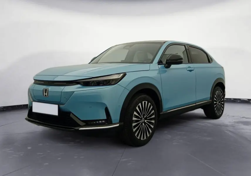 Honda e:Ny1 204 ch Advance bleu électrique, vue 3/4 avant droit mettant en valeur ses jantes stylisées et son design moderne.