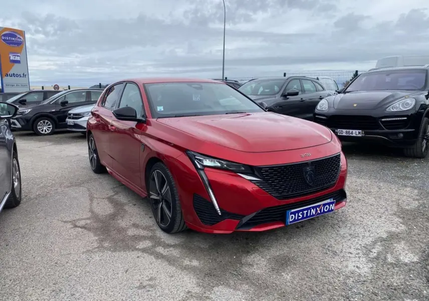 Peugeot 308 GT rouge Elixir vue 3/4 avant droit, avec calandre noire et phares LED distinctifs.