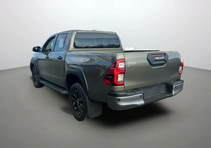 Toyota Hilux 4x4 2025 bronze impérial, vue 3/4 arrière droit mettant en valeur la benne et les feux arrière rouges.